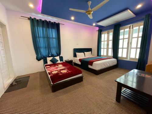 a bedroom with a bed and a table and a couch at Sarfaranga Residency in Skardu