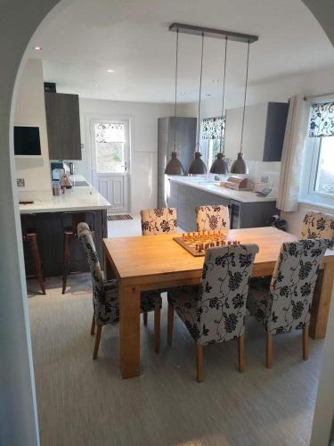 a kitchen with a wooden dining room table and chairs at Doonhill in Portpatrick in Portpatrick
