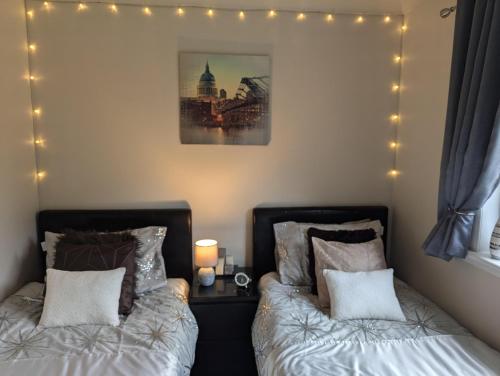 two beds in a bedroom with lights on the wall at Doonhill in Portpatrick in Portpatrick