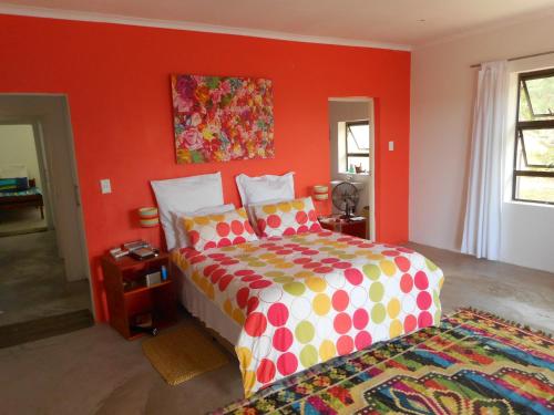 a bedroom with a large bed with orange walls at Lala Kahle in Sodwana Bay