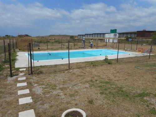 a swimming pool in a field with a building at Lala Kahle in Sodwana Bay