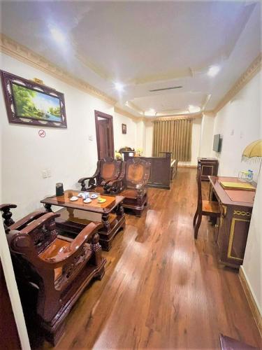 a living room with a table and a piano at New Pacific Hotel in Ho Chi Minh City