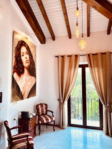 a living room with a painting of a woman at Hotelito Suecia in Granada