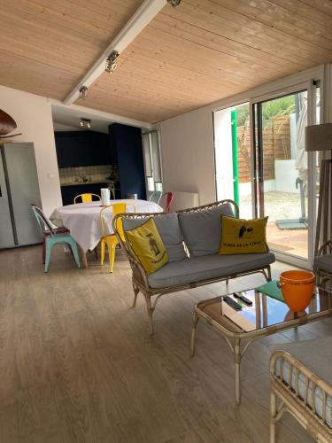 a living room with a couch and a table at Calme et Tranquillité in Rivedoux-Plage