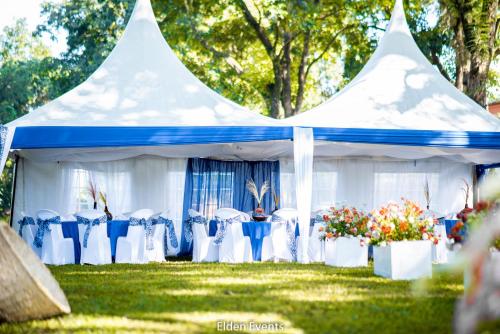 a white tent with blue chairs and tables at Golf Hotel Kakamega in Kakamega
