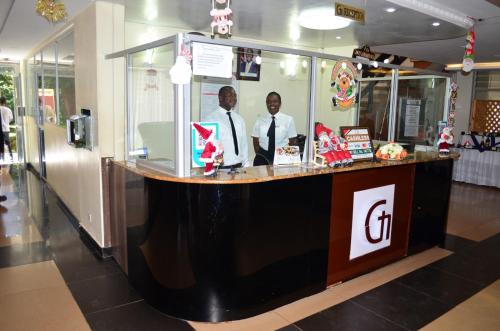 two men standing at a counter in a restaurant at Golf Hotel Kakamega in Kakamega