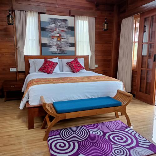 a bedroom with a large bed with a blue bench at Otila Bali Villa in Uluwatu