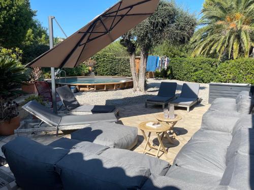 une terrasse avec des canapés et des chaises ainsi qu'une piscine dans l'établissement Villa vue mer presqu'ile de giens avec piscine, à Hyères