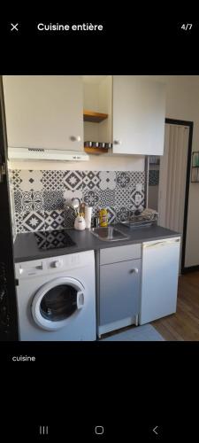 une cuisine avec une machine à laver et un évier dans l'établissement Studio cosy proche de Paris et Orly, à Ville Héry