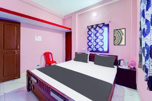 Un dormitorio con una cama grande y una silla roja. en Hotel O S Hotel & Restaurant, en Patna