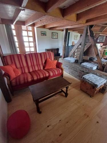 un salon avec un canapé rouge et une table dans l'établissement Maison en campagne style western, à Halluin
