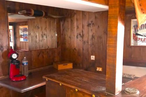 une cuisine avec des murs en bois et un comptoir avec un appareil rouge dans l'établissement Maison en campagne style western, à Halluin