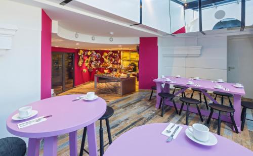 a dining room with purple tables and chairs at Swiss Wine by Fassbind in Lausanne