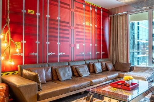 a living room with a brown couch and red walls at Paradise of the Mind by Lagom in Dubai