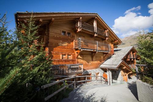 a large wooden house with a staircase in front of it at Residence Bastide in Verbier