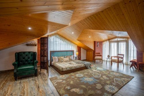 a bedroom with a bed and a green chair at ELIVAAS 4 BHK With Garden & Bonfire - Fleur De Lis in Kasauli