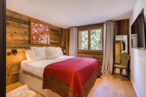 Un dormitorio con una cama en una habitación con paredes de madera. en Résidence Fitz Roy, en Combloux