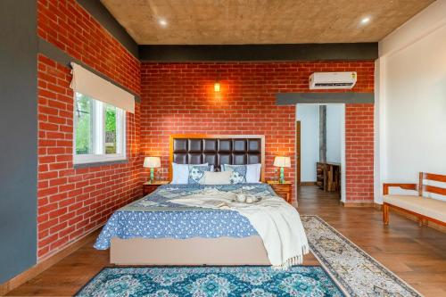a bedroom with a red brick wall and a bed at ELIVAAS 4 BHK With Garden & Bonfire - Fleur De Lis in Kasauli