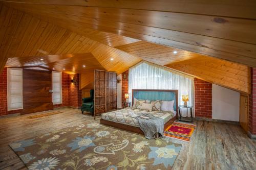 a bedroom with a bed in a room with wooden ceilings at ELIVAAS 4 BHK With Garden & Bonfire - Fleur De Lis in Kasauli