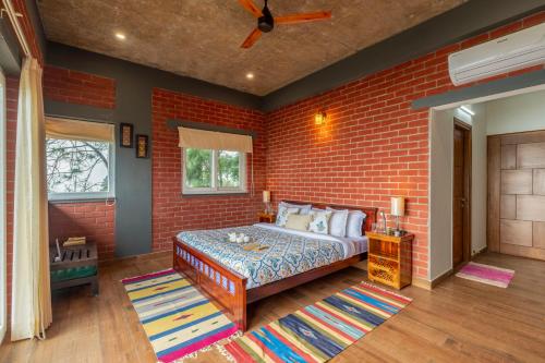 a bedroom with a brick wall and a bed at ELIVAAS 4 BHK With Garden & Bonfire - Fleur De Lis in Kasauli
