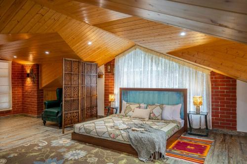 a bedroom with a bed and a wooden ceiling at ELIVAAS 4 BHK With Garden & Bonfire - Fleur De Lis in Kasauli