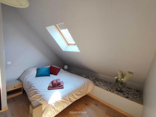 a bedroom with a bed with a pair of shoes on it at Maisonnette avec jardin in Chamilly