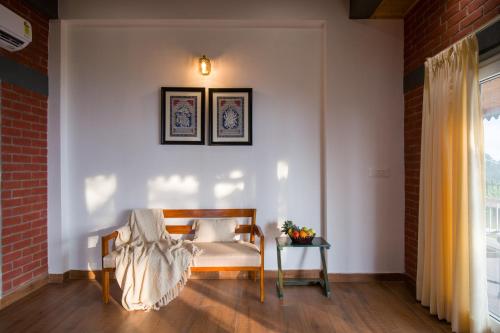 a living room with a chair and a table at ELIVAAS 4 BHK With Garden & Bonfire - Fleur De Lis in Kasauli