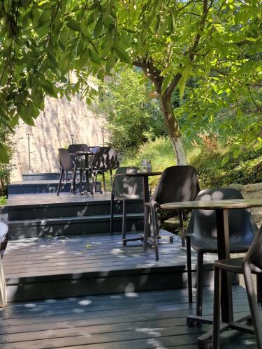 a row of tables and chairs on a wooden deck at Pensiunea Casa Dimitrios-Baile Herculane -Casă Boemă cu vedere la munte apă atmosferă intimă in Băile Herculane