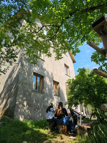 two people sitting in front of a building at Art Racha in Ambrolauri