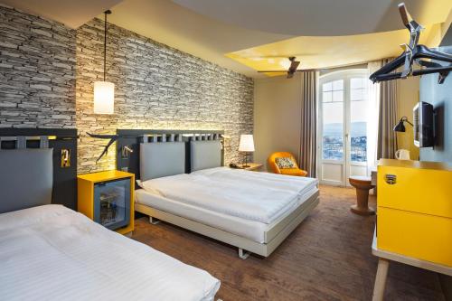 ローザンヌにあるスイス ワイン バイ ファスビントのレンガの壁、ベッド2台が備わるベッドルーム1室が備わります。