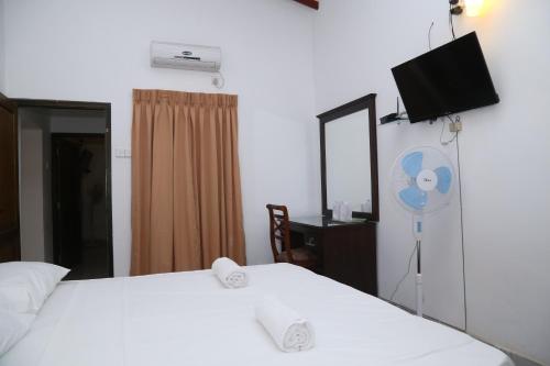 a hotel room with two beds and a fan at Kandy Moon Hills Hotel in Kandy