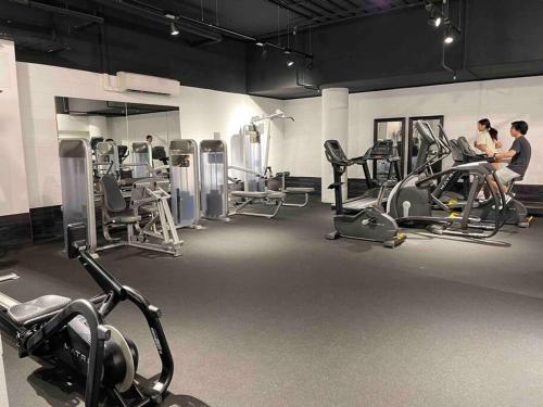 a gym with several people exercising on tread machines at Stylish Chatswood 2BR Apartment with 3 Beds, Gym, Near Metro in Sydney