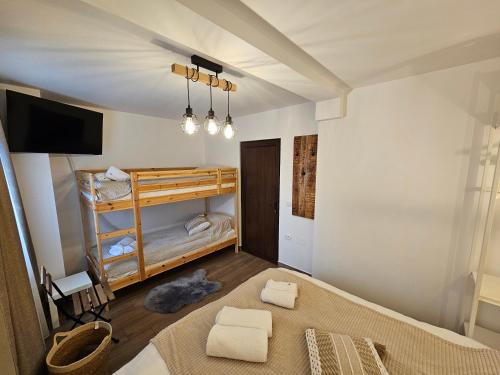 a bedroom with a bed and a tv in a room at Casa Lia Voroneț in Voroneţ