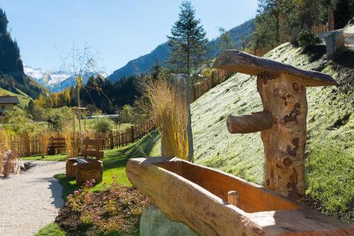 a statue of a wooden sink on a hill at Chaletdorf Auszeit in Hüttschlag