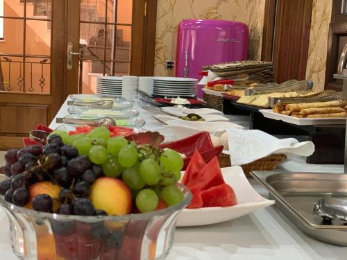 a table with a bunch of fruit in a bowl at Yaffle Inn Shaki Boutique Hotel in Sheki