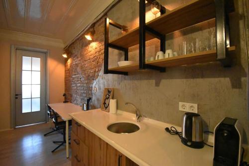 a kitchen with a sink and a brick wall at Stunning 6BR 4Bath near Tram in Istanbul