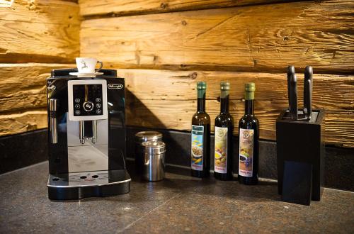 a row of wine bottles next to a coffee maker at Chaletdorf Auszeit in Hüttschlag