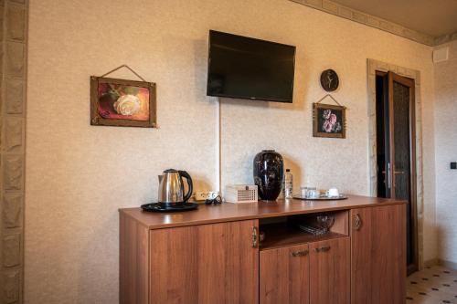 a room with a wooden cabinet with a television on the wall at Castel Unghern in Ivancea