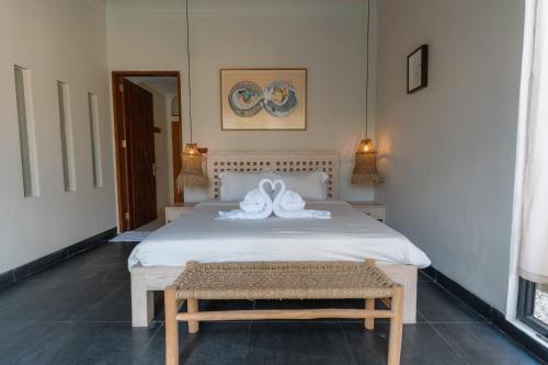 a bedroom with a bed with two white towels on it at Villa GMT Canggu - By Bali Lyfe Venture in Canggu