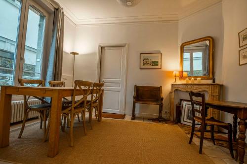 a dining room with a table and chairs and a fireplace at La maison du 18 in Chantilly