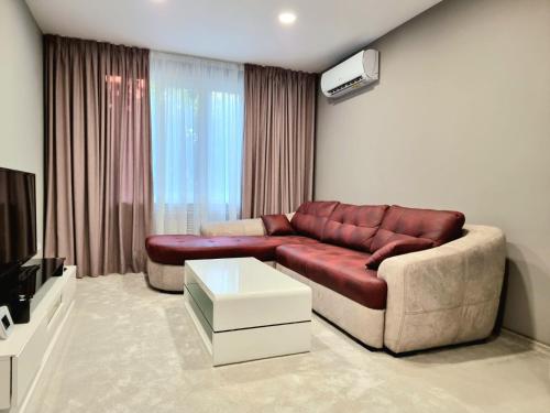 a living room with a couch and a tv at Alexandrovska - Super Centar Luxury Apartment in Burgas City