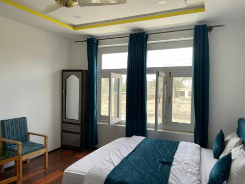 a bedroom with a bed and a window and a chair at Sarfaranga Residency in Skardu
