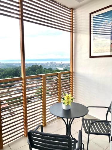 a balcony with a table and chairs and a large window at Prima at Primavera City, CDO in Cagayan de Oro