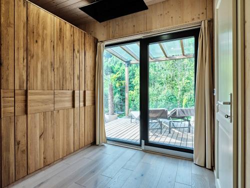 a room with wooden walls and a sliding glass door at Lelis Alpenloft - Bergchalet in Halden in Mittelberg