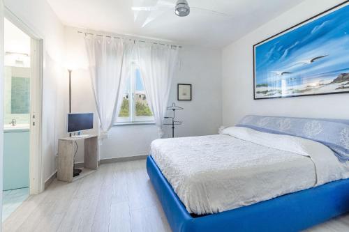 a white bedroom with a bed and a television at CASAVIVA - Villa con piscina privata a Stintino in Stintino
