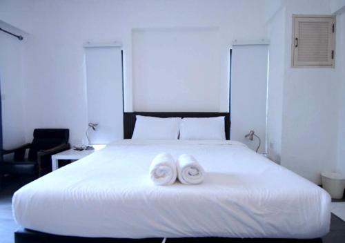 a white bed with two towels on top of it at isleep guesthouse in Chiang Mai