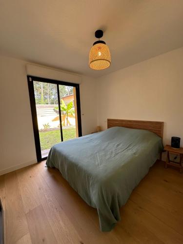 une chambre avec un lit et une grande fenêtre dans l'établissement Charmant T3 à la plage, à Seignosse