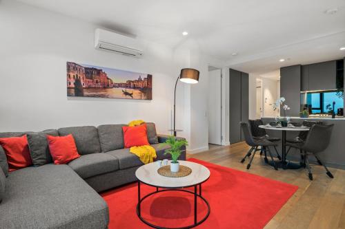 a living room with a couch and a red rug at Gorgeous City Views 71st Floor 3BR Apartment with Pool and Gym in Melbourne