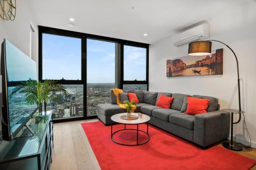 a living room with a couch and a red rug at Gorgeous City Views 71st Floor 3BR Apartment with Pool and Gym in Melbourne