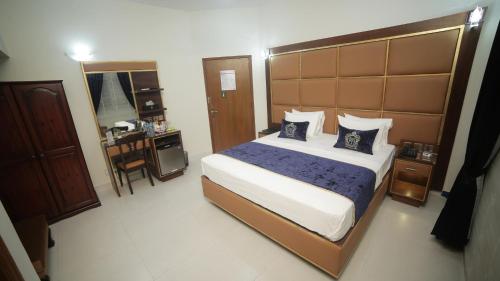 a bedroom with a large bed with blue pillows at Four Squares by WI Hotel in Karachi